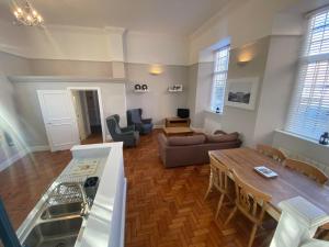 a kitchen and living room with a table and a couch at Crowcombe Court in Crowcombe