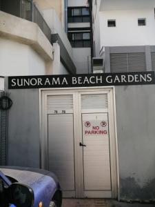 a building with two garage doors with a sign on it at Quattro Beachfront Sea View Ap 206 in Larnaka