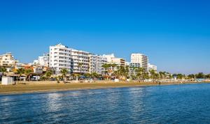 a view of a beach with buildings in the background at Quattro Sea View Beachfront Ap.206 in Larnaca