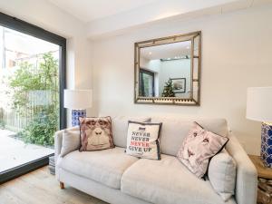 ein Wohnzimmer mit einer Couch und einem Spiegel in der Unterkunft Fawcett Cottage in Aldeburgh