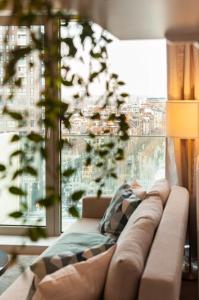 - un canapé dans le salon doté d'une grande fenêtre dans l'établissement The Wonder Shore, à Anvers