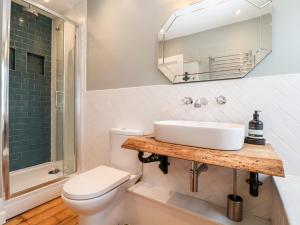 ein Badezimmer mit Waschbecken, Toilette und Spiegel in der Unterkunft Fawcett Cottage in Aldeburgh + 22 Fotos