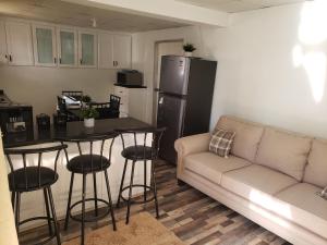 a living room with a couch and a table and a refrigerator at Mango Vert Apartment in Arima