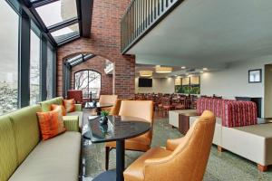 een lobby met tafels en stoelen en een restaurant bij Pear Tree Inn St. Louis - Arnold in Arnold