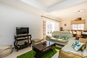 a living room with a couch and a tv at AYAMI Villa in Setúbal