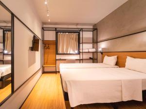 1 dormitorio con 2 camas y ventana en ibis Cuiaba Shopping, en Cuiabá