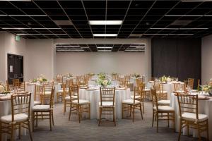 um salão de banquetes com mesas e cadeiras com toalhas de mesa brancas em BEI San Francisco, Trademark Collection by Wyndham em São Francisco