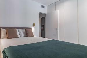 a bedroom with a large bed with a green blanket at Luxury apartment - Free Parking - Duomo-Navigli in Milan