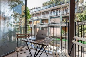 an apartment balcony with a laptop on a table at Luxury apartment - Free Parking - Duomo-Navigli in Milan