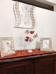 a table with a vase of flowers and a clock at Casa Anseramo in Bisceglie
