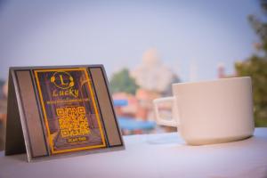 uma chávena de café sentada ao lado de uma placa e uma caneca em Lucky Restaurant & Guest House em Agra