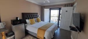 a bedroom with a large bed and a television at Collards B&B in Durban
