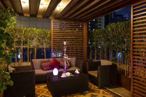 a patio with a couch and a table with a candle at Ramada by Wyndham Dubai Barsha Heights in Dubai