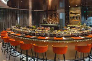 a large round table with orange chairs in a room at Ramada by Wyndham Dubai Barsha Heights in Dubai