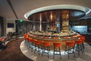 a large bar with orange chairs in a room at Ramada by Wyndham Dubai Barsha Heights in Dubai