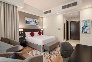 a bedroom with a bed and a living room at Ramada by Wyndham Dubai Barsha Heights in Dubai