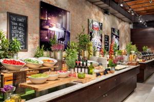 a buffet line with vegetables and wine bottles at Vienna House by Wyndham Andel's Lodz in Łódź