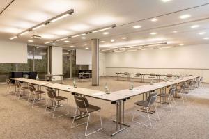 uma grande sala de conferências com uma mesa longa e cadeiras em Vienna House Easy by Wyndham Stuttgart em Stuttgart