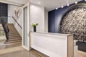 a hallway with blue walls and stairs with a vase of flowers at Wyndham Grand Krakow Old Town in Kraków