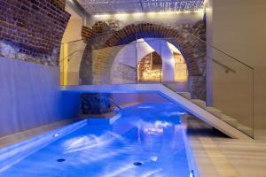 a swimming pool in a house with a brick wall at Wyndham Grand Krakow Old Town in Kraków