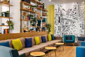 a room with a couch and some chairs and a wall at Vienna House Easy by Wyndham Cracow in Krakow