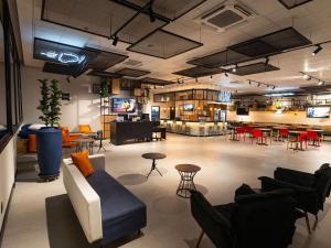 a large room with couches and chairs and a table at ibis Barra do Garcas in Barra do Garças