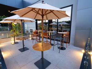 um restaurante com mesas e cadeiras com guarda-sóis em ibis Barra do Garcas em Barra do Garças