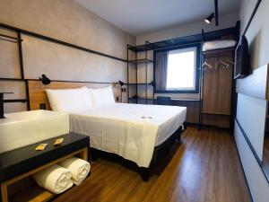 a hotel room with a bed and a sink at ibis Barra do Garcas in Barra do Garças