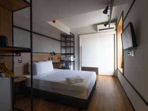a bedroom with a bed and a television in it at ibis Barra do Garcas in Barra do Garças
