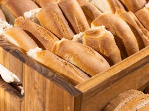 a bunch of loaves of bread in a wooden bin at ibis Barra do Garcas in Barra do Garças