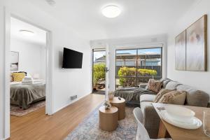 ein Wohnzimmer mit einem Sofa und einem Tisch in der Unterkunft Wilson Executive Apartments in Thomson