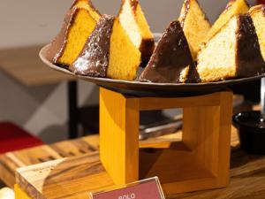 a plate of cake on top of a wooden stand at ibis Barra do Garcas in Barra do Garças