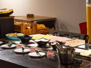 a table topped with plates and bowls of food at ibis Barra do Garcas in Barra do Garças