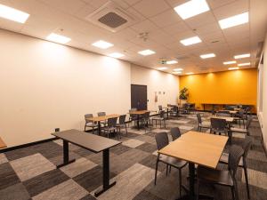 a classroom with tables and chairs and a chalkboard at ibis Barra do Garcas in Barra do Garças
