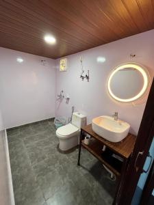 y baño con aseo, lavabo y espejo. en Nivriti Stays, en Kanatal