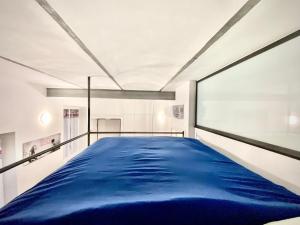 un grand lit dans une chambre avec une grande fenêtre dans l'établissement Irene House Malpensa Milan Lakes, à Busto Arsizio
