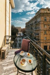 d'un balcon avec une table en verre et de la nourriture. dans l'établissement Nizami Boutique by La Casa, à Baku
