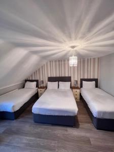 1 dormitorio con 2 camas y lámpara de araña en Fiddlestone Bar and B&B en Belleek