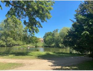 a view of a lake with a building in the background at Dorset Lodge Flat 3 in Gloucestershire +10 photos