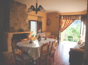 a dining room with a table and a fireplace at CORTIJO COLOMO in Almedinilla