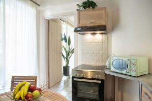a kitchen with a microwave and a bowl of fruit on a table at Vicky's Sky Loft in Piraeus