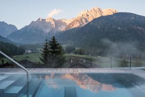 a swimming pool with a view of mountains at Paramount Alma Suites in Sesto