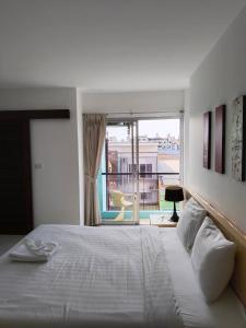 a bedroom with a large bed and a large window at Urban Patong Residence in Patong Beach
