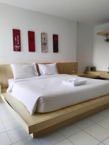 a large bed with a wooden frame in a bedroom at Urban Patong Residence in Patong Beach