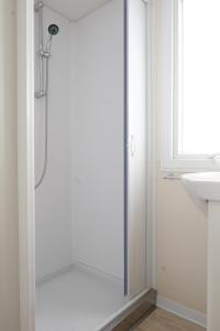 a shower with a glass door in a bathroom at Happy Camp Mobile Homes in Camping Karavomilos Beach in Sami