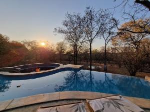 a swimming pool with a fire pit in the middle at Pata Pata House in Marloth Park