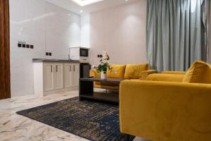 sala de estar con muebles de color amarillo y cocina en لحظات الفندقية حراء, en Yeda