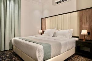 a bedroom with a large white bed with a large headboard at لحظات للشقق المخدومة in Jeddah
