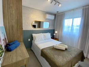 a hotel room with a bed and a mirror at Green Porto 103 Flat novíssimo no centro de Porto in Porto De Galinhas