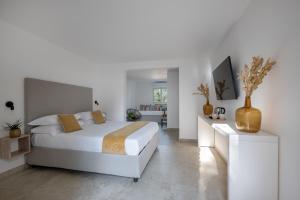 a white bedroom with a bed and a desk at Sopramare Resort in Piano di Sorrento